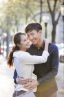 Китайская пара обнимается на улице — стоковое фото
