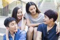 Amigos chineses conversando juntos nas escadas — Fotografia de Stock
