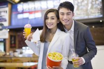 Chinese couple going to movie theater with popcorn — Stock Photo