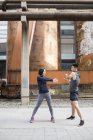 China pareja estiramiento en la calle - foto de stock
