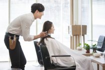 Barbier chinois travaillant dans le salon de coiffure — Photo de stock