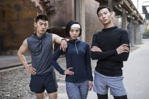 Atletas chinos de pie en la calle y mirando en la cámara - foto de stock