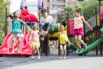 Niños chinos jugando en el parque de atracciones - foto de stock