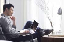 Азіатських людині працювати з ноутбуком в офісі — стокове фото