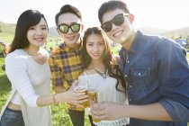 Chinese friends holding beer and looking in camera — Stock Photo