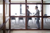Asian businessmen talking in meeting room — Stock Photo