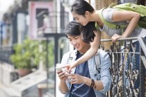 Китайская пара использует смартфон на улице — стоковое фото