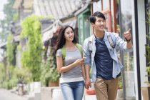 Chinese couple walking on street in Beijing with smartphone — Stock Photo