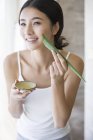 Chinese woman applying natural aloe vera moisturizer — Stock Photo
