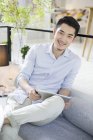 Hombre chino usando tableta digital en la cafetería - foto de stock