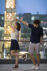 Jeune couple chinois dansant sur la terrasse du bâtiment — Photo de stock