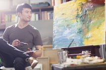Художник из Азии, работающий в художественной студии — стоковое фото