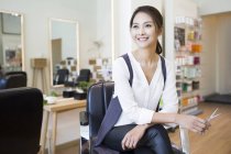 Female chinese barber sitting in shop — Stock Photo