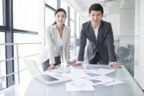 Chinese business people standing in meeting room — Stock Photo