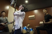 Chinese musical band recording song in studio — Stock Photo