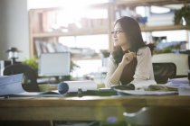 Femme asiatique architecte assis dans bureau — Photo de stock