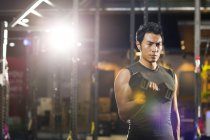 Chinese man lifting weights at gym — Stock Photo