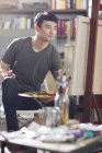 Asiático pintor masculino trabalhando no estúdio de arte — Fotografia de Stock