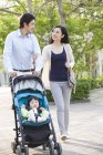Asian couple walking in park with baby girl — Stock Photo