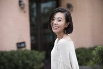 Portrait of young Chinese woman looking in camera and laughing — Stock Photo