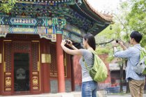 Casal chinês tirando fotos com smartphones em Lama Temple — Fotografia de Stock