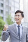 Chinese businessman standing on street and cheering — Stock Photo