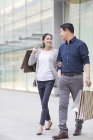 Mature chinese couple shopping in city — Stock Photo
