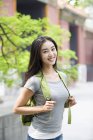 Chinese woman with backpack standing on street — Stock Photo