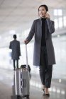 Азіатський жінка, розмовляємо по телефону в аеропорту — стокове фото