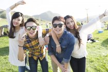 Chinese friends gesturing at music festival camping — Stock Photo