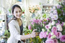 Mujer china comprando flores en la tienda - foto de stock