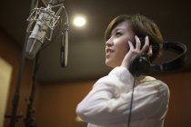 Mujer china cantando en estudio de grabación - foto de stock