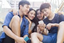 Chinese friends looking at smartphone screen together — Stock Photo