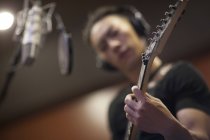 Hombre chino tocando la guitarra en estudio de grabación - foto de stock