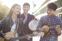 Amici cinesi che suonano strumenti musicali per strada — Foto stock
