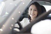 Китайська жінка, що сидить у автомобіль на стоянці — стокове фото