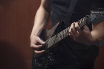 Vista de cerca de manos masculinas tocando la guitarra - foto de stock