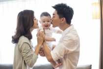 Genitori cinesi baciare bambino ragazzo sulle guance — Foto stock