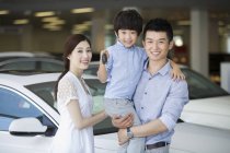 Chinese family in car dealership showroom with car keys — Stock Photo