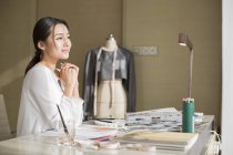 Créateur de mode chinois reposant à table en studio — Photo de stock