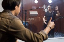 Chinese men recording with guitar in studio — Stock Photo