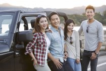 Chinesische Freunde posieren mit Auto in Vororten — Stockfoto