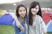 Chinese women embracing at festival camping — Stock Photo