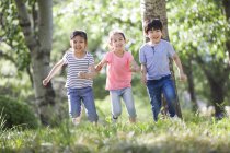 Enfants chinois en course dans les bois — Photo de stock