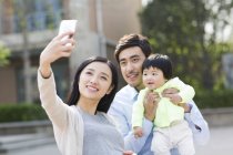 Asian couple taking selfie with baby girl — Stock Photo