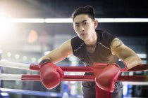 Азиатский боксёр отдыхает на ринге — стоковое фото