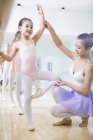 Chinese ballet instructor teaching girls in ballet studio — Stock Photo