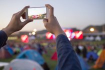 Мужчина фотографирует со смартфоном на музыкальном фестивале — стоковое фото