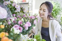 Mujer china comprando flores en la tienda - foto de stock