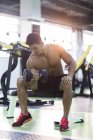 Chinese man lifting dumbbell at gym — Stock Photo